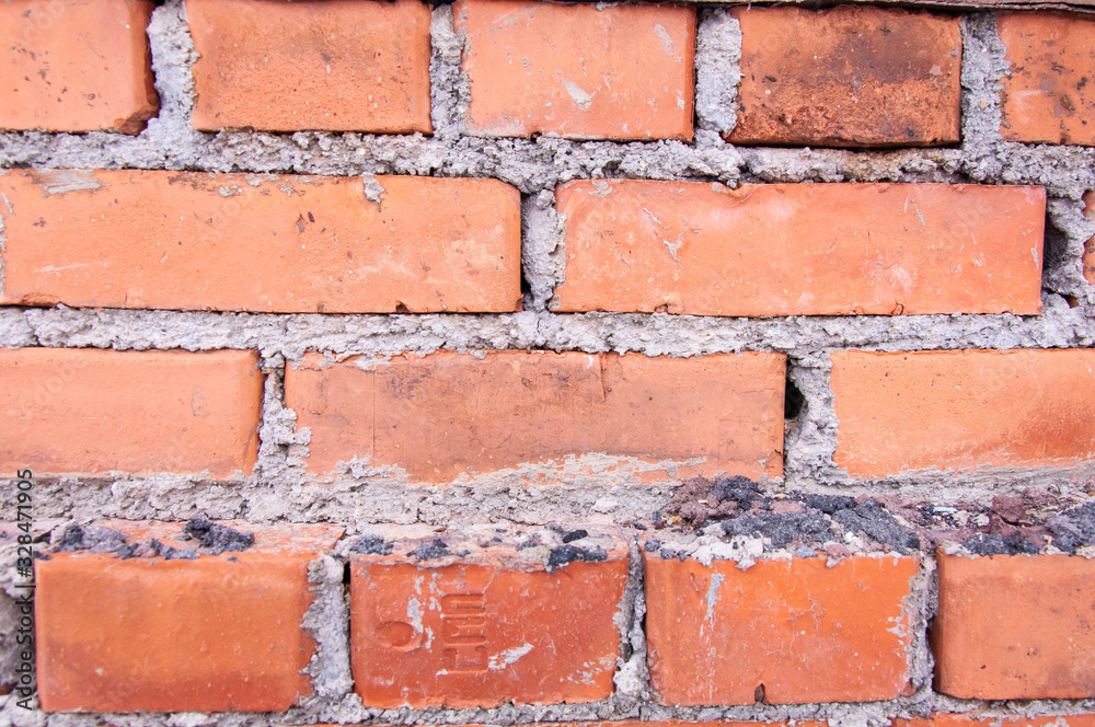 Fototapeta premium red brick house wall masonry under snow, background, texture, red brick masonry