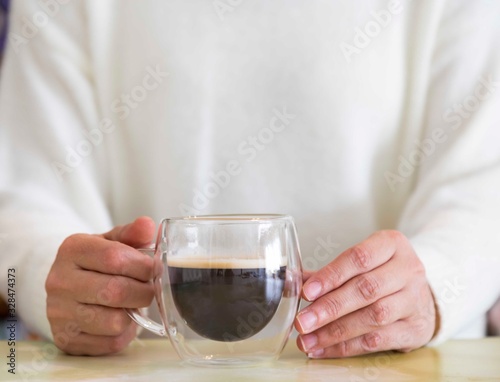 Transparent double wall glass mug with espresso coffee at home at work
