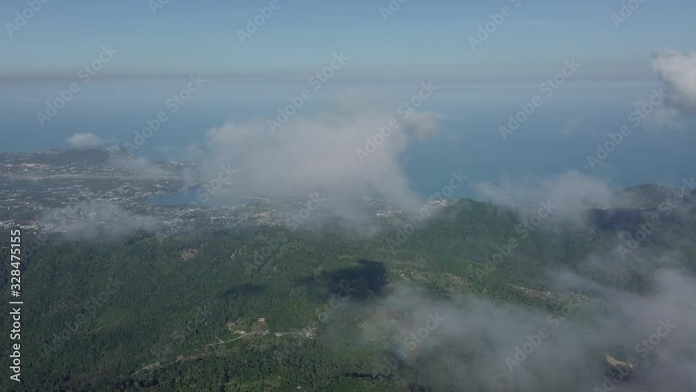 High altitude - drifting clouds and jungle landscape - drone going down through the cloud layer High altitude - drifting clouds and jungle landscape - drone going down through the cloud layer