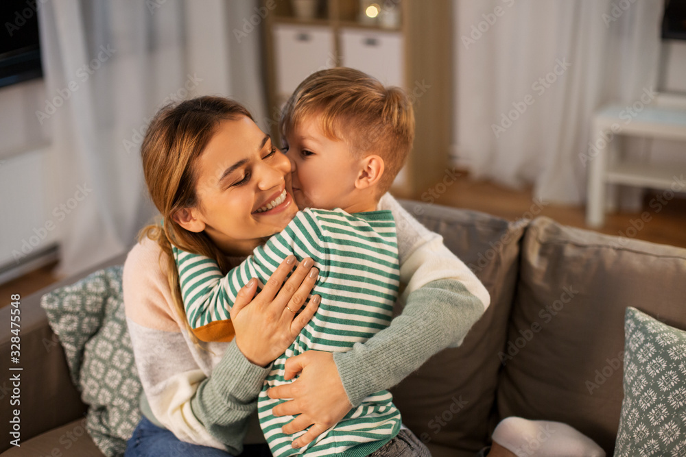 family, love and people concept - happy smiling mother and little son hugging and kissing at home in evening family, love and people concept - happy smiling mother and little son hugging and kissing at home in evening