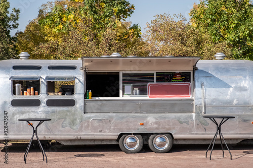 Classic chrome food wagon in park. Food truck. photo