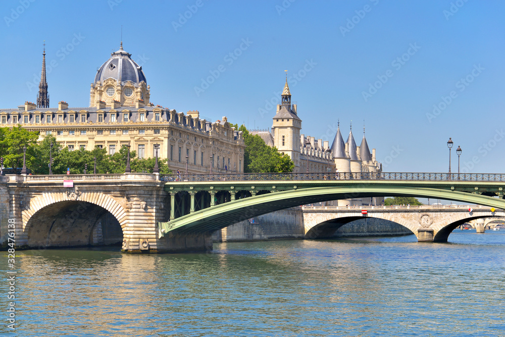 view on ancient building of the conciergerie and bridge of Sully from river the seine
