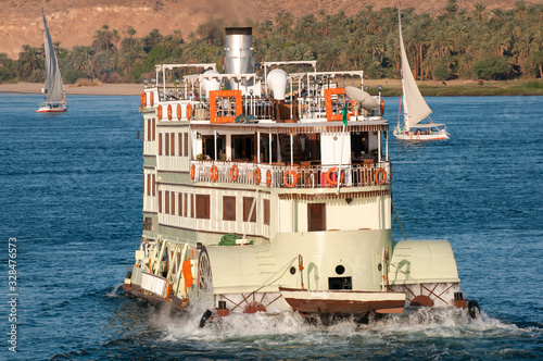 Φωτογραφία Sunny view of traditional paddle steamer riverboat churning up the waters with t