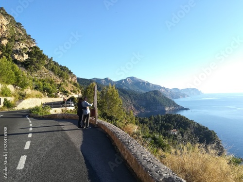 Fototapeta Naklejka Na Ścianę i Meble -  Mallorca, Spain, June 02 nd 2019: Couple in love looking at the map. Panoramic road next to the sea.