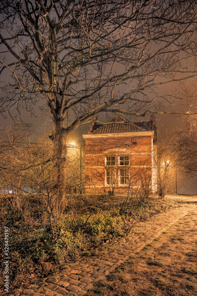 Foggy night scene small illuminated brick dike house Foggy night scene small illuminated brick dike house