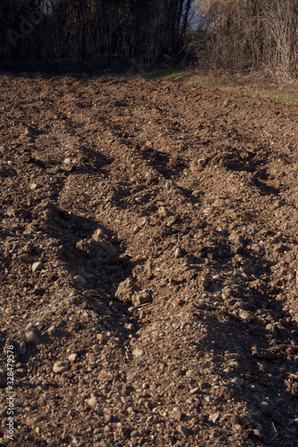 Plowed field in the italian countryside on a sunny day. Agricultural field on winter season