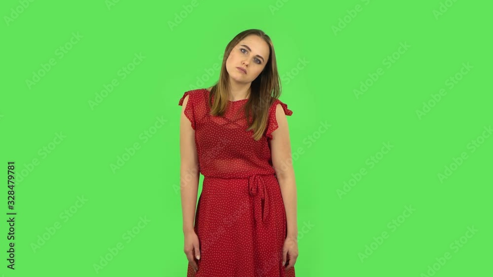 Tender girl in red dress is upset and tired. Green screen