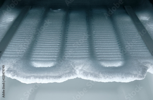 Time to defrost : View into the freezer on cooling coils completely covered with ice. photo