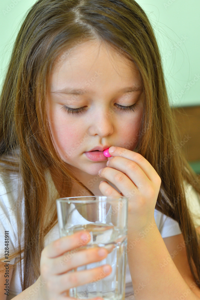 Little child girl takes pills against colds and fluSick child with napkin in bed. Allergic kid, flu season. Kid with cold rhinitis, get cold snot nose. virus and infection Little child girl takes pills against colds and fluSick child with napkin in bed. Allergic kid, flu season. Kid with cold rhinitis, get cold snot nose. virus and infection