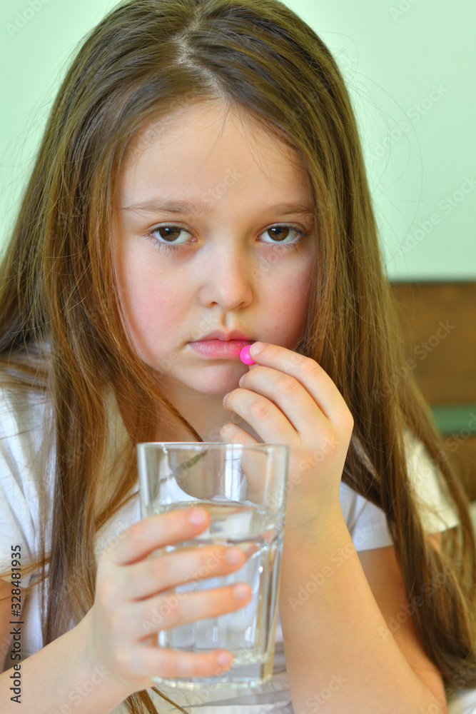 Little child girl takes pills against colds and fluSick child with napkin in bed. Allergic kid, flu season. Kid with cold rhinitis, get cold snot nose. virus and infection Little child girl takes pills against colds and fluSick child with napkin in bed. Allergic kid, flu season. Kid with cold rhinitis, get cold snot nose. virus and infection