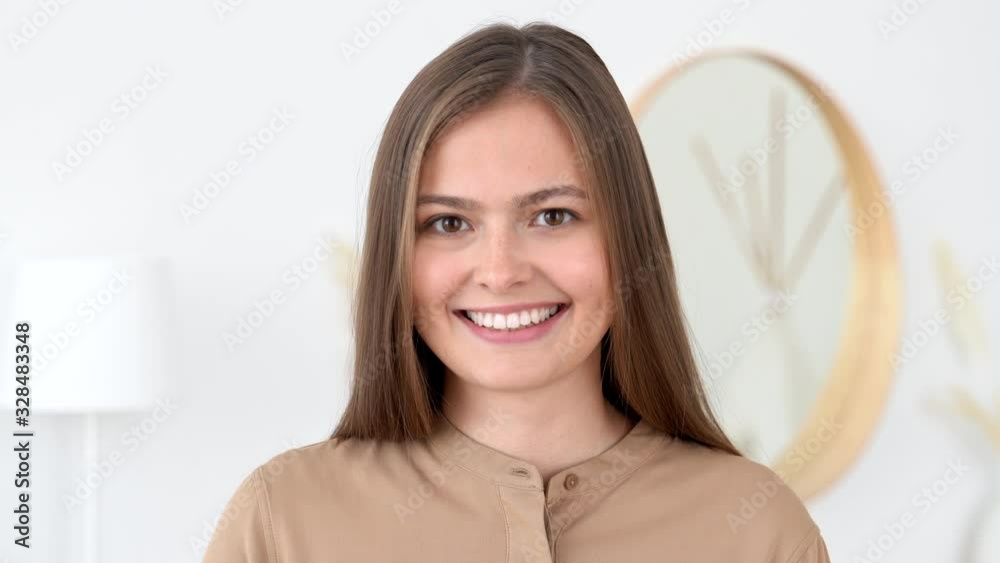 Interior portrait of smiling and laughing young woman looking at camera Interior portrait of smiling and laughing young woman looking at camera