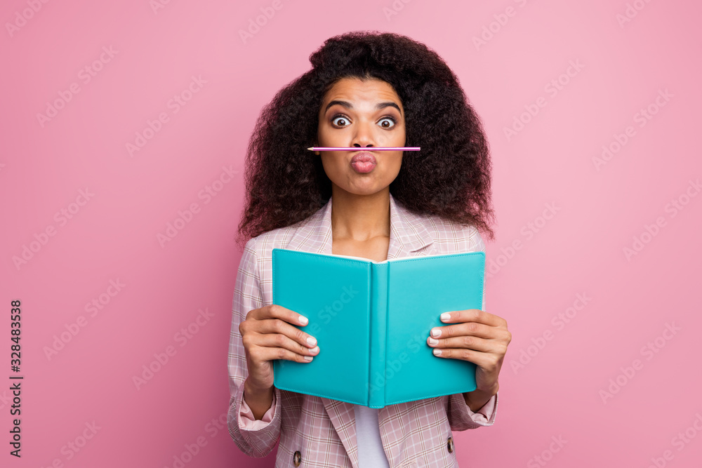 Photo of funny foolish dark skin student lady hold journal book not reading playing pen make fake mustache wear checkered blazer isolated pastel pink color background Photo of funny foolish dark skin student lady hold journal book not reading playing pen make fake mustache wear checkered blazer isolated pastel pink color background