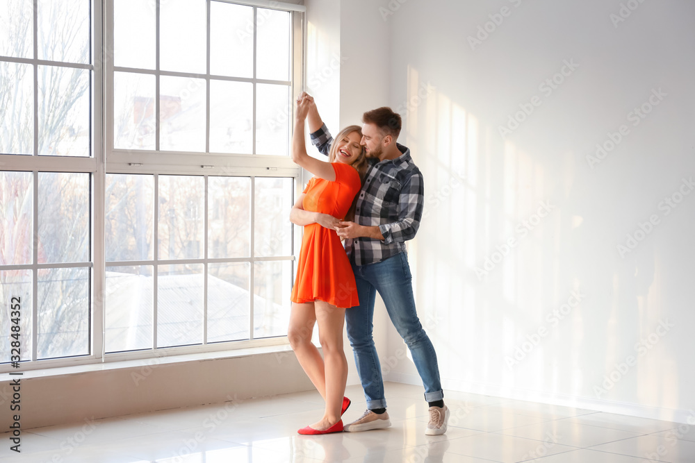 Happy young couple dancing at home