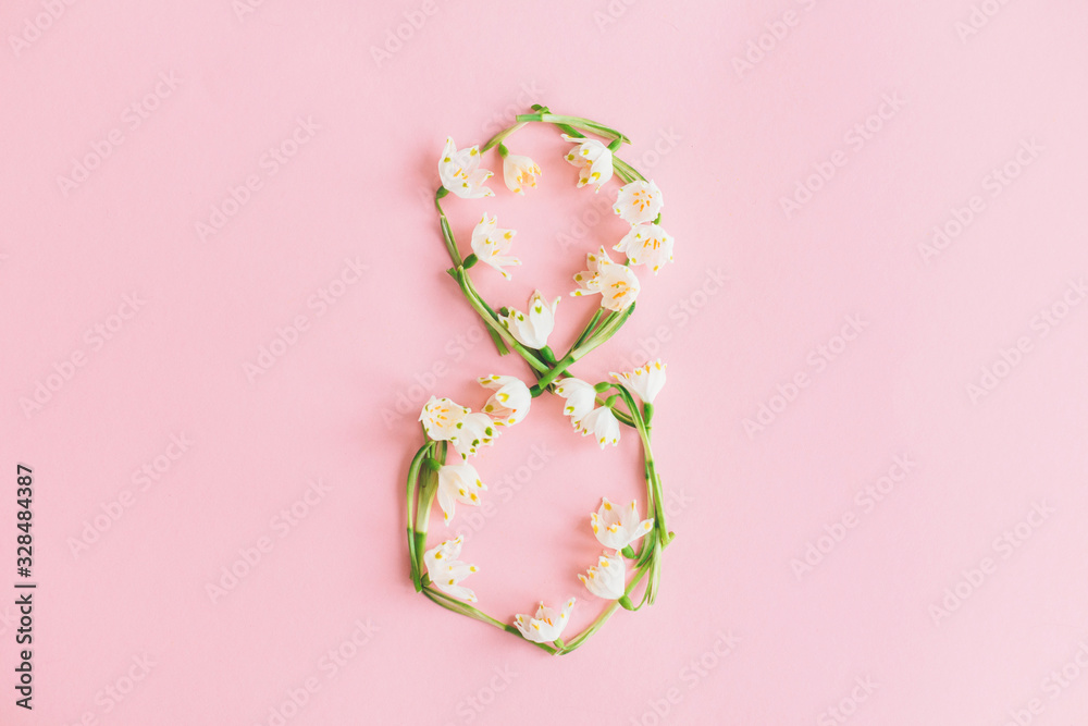 Fototapeta premium 8 march. Floral number 8 made of spring flowers on pink background, stylish spring greeting card. Happy womens day concept. International women's day. Flat lay