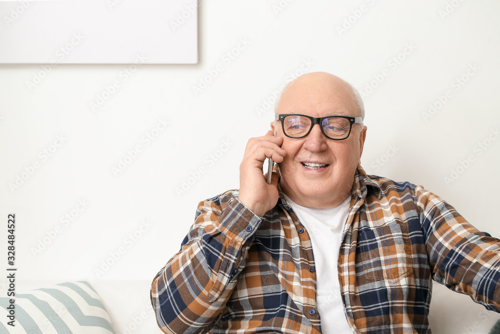 Portrait of elderly man talking by phone at home Portrait of elderly man talking by phone at home