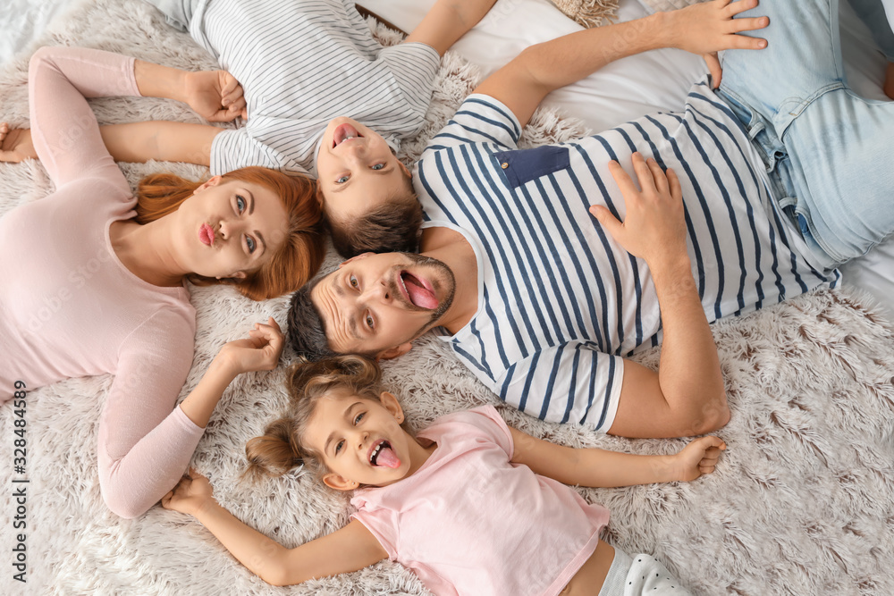 Happy family having fun on bed at home