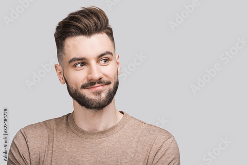 Closeup portrait of handsome smiling young man. Laughing joyful cheerful men studio shot. Isolated on gray background 