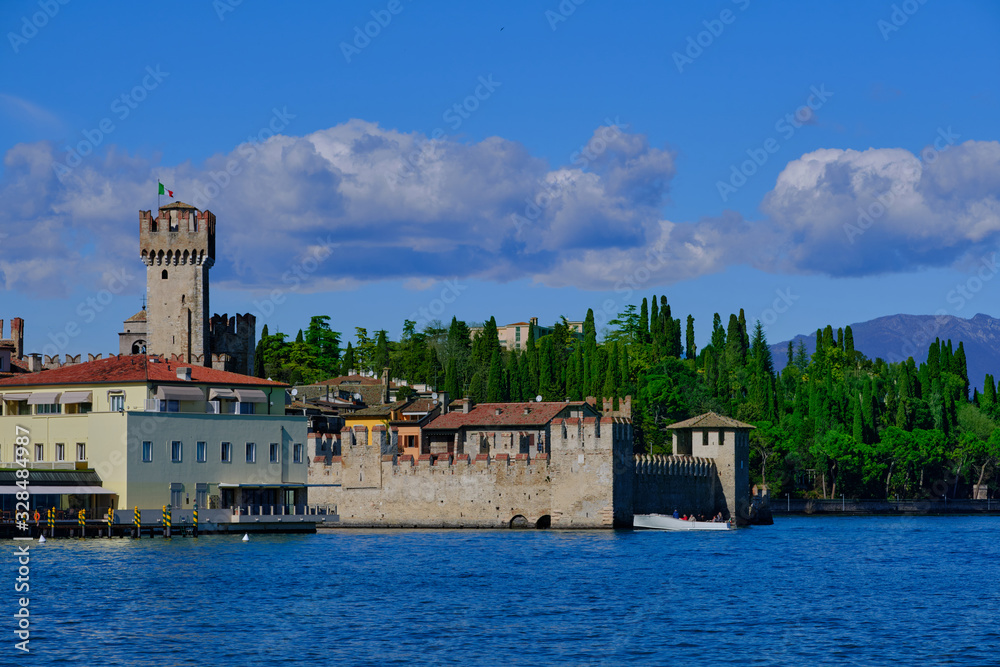 Rocca Scaligera Castle in Sirmione Lake Garda, Italy. Boat with tourists on the background of the castle