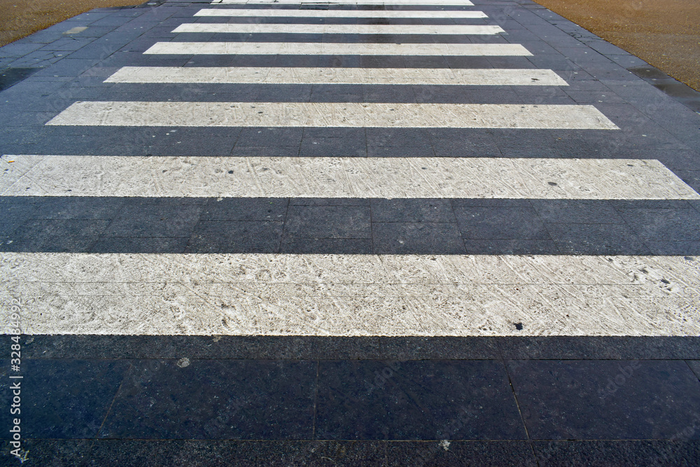 Closeup of white and black pedestrian crosswalk on the road in the city center. Safety and take care concept. Closeup of white and black pedestrian crosswalk on the road in the city center. Safety and take care concept.