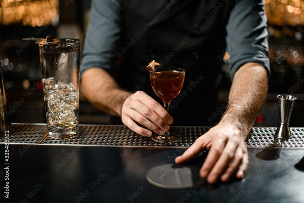 Hands of a bartender at bar restaurant with wineglass