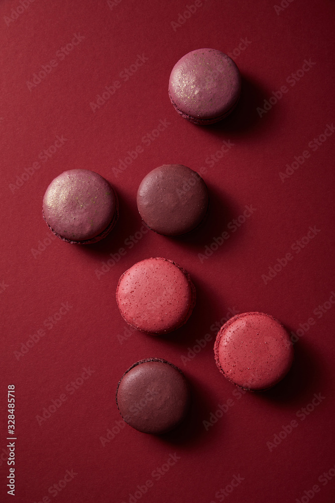 top view of delicious colorful french macaroons on red background top view of delicious colorful french macaroons on red background