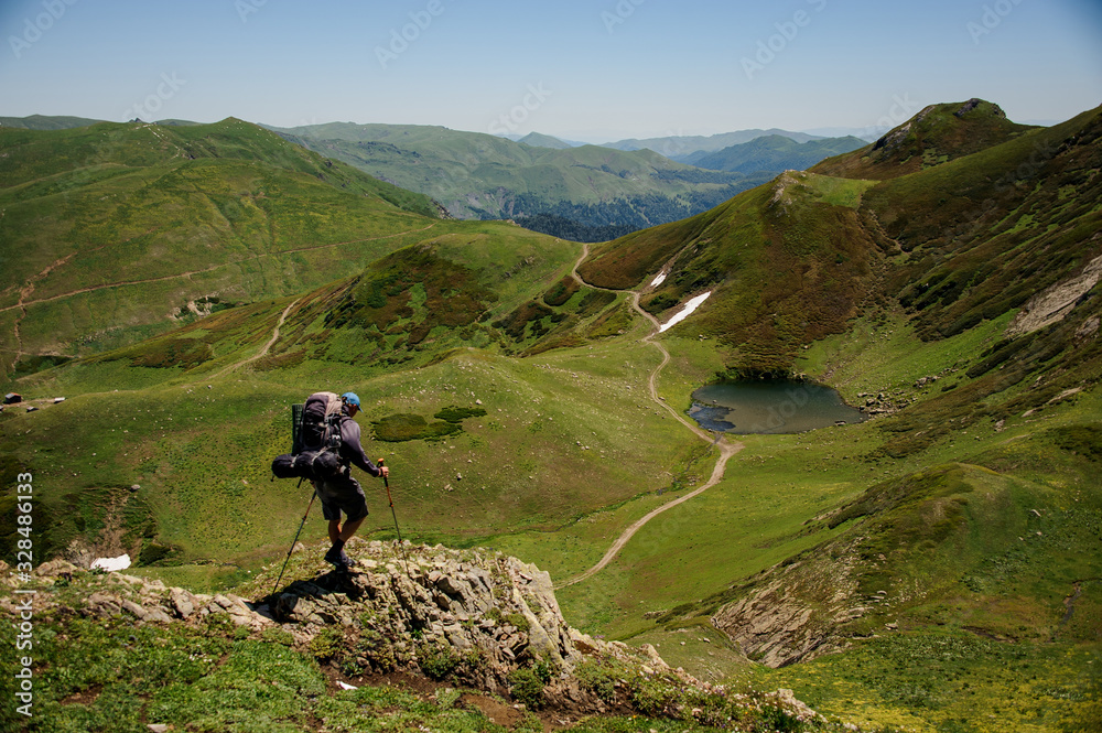 One man hiking in the mountains using poles