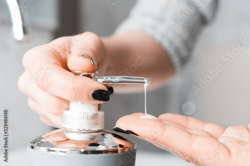 Effective handwashing techniques: Woman soaping her hands through a soap dispenser. Hand washing is very important to avoid the risk of contagion from coronavirus and bacteria.