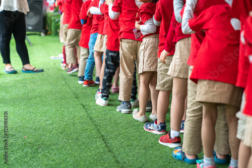 Queue of Asian kids in school uniform standing in line