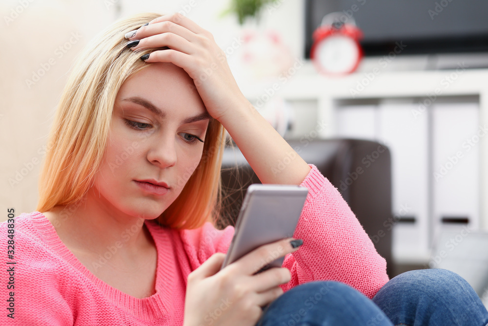 young pretty blond womansit on sofa hold smartphone in hands chat with friends young pretty blond womansit on sofa hold smartphone in hands chat with friends