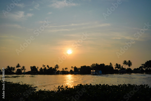 beautiful Sea side sunset behind coconut trees in Kerala India. 