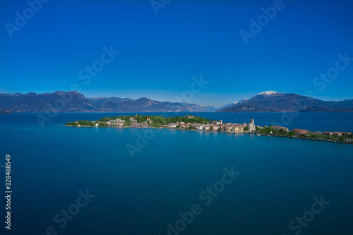 Sirmione island Lake Garda  Italy. Aerial view. In the background mountains in the snow and blue sky