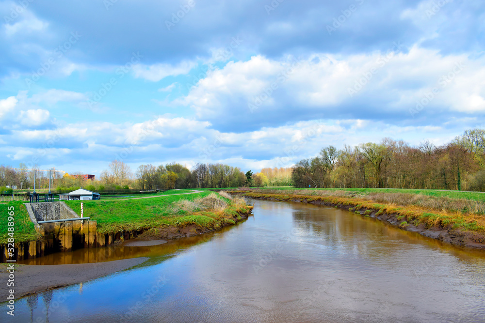 Beautiful landscape of the tree and canal with blue and grey sky nature background in sunshine day and good weather at spring or summer season at Lier, Antwerp, Belgium. Travel and holiday concept.