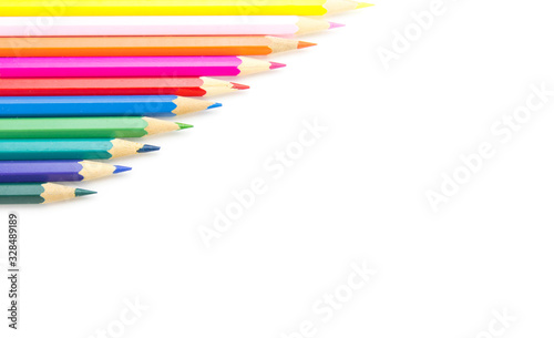 Multicolored wooden sharpened pencils neatly folded with a ladder on a large isolated background in the corner. There is free space for text.