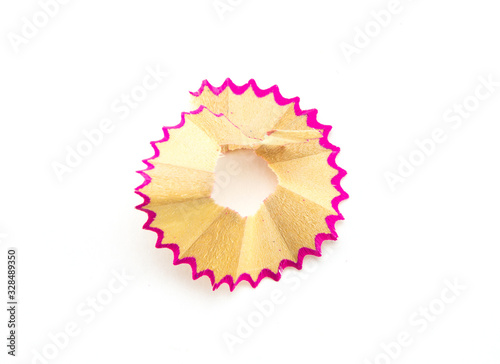 Round neat shavings from sharpening a wooden pencil with a pink border. White isolated background, close-up shot