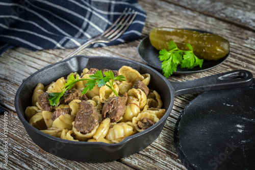 Italian pasta shells with beef sauce in cast iron pan.