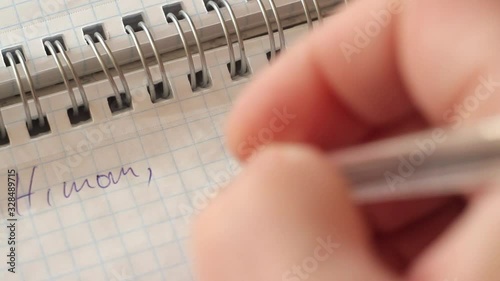 the guy writes with a pen in a notebook a mother’s farewell letter and crosses it out: Hi mom, if you read it ... extreme close-up of a hand. Full HD photo
