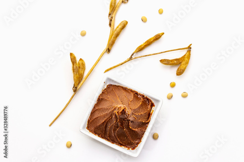 Light brown miso paste isolated on white background. Traditional Japanese seasoning, dry soya beans pods