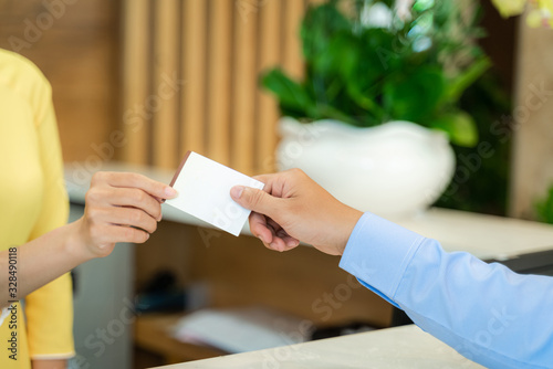 Vietnamese hotel receptionist in traditional dress Ao Dai giving key card