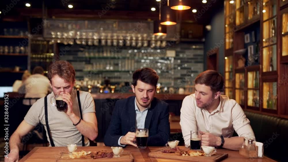 the men at the bar give five to each other and drink beer the men at the bar give five to each other and drink beer
