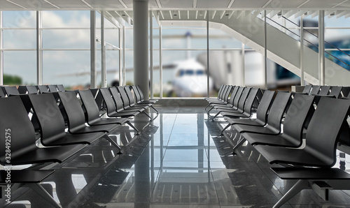 Rows of black chairs at airport and plane standing