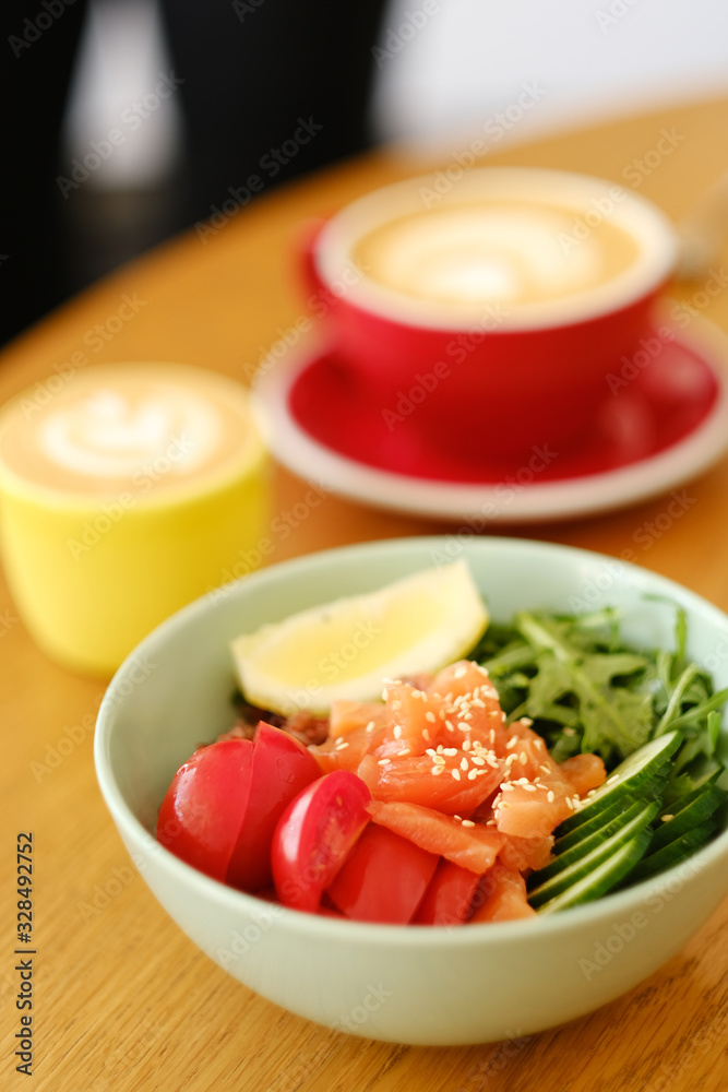 Healthy breakfast. Tasty breakfast in a cafe: tomatoes, salmon, cucumber, arugula in a deep blue plate on a wooden table. Healthy breakfast. Tasty breakfast in a cafe: tomatoes, salmon, cucumber, arugula in a deep blue plate on a wooden table.
