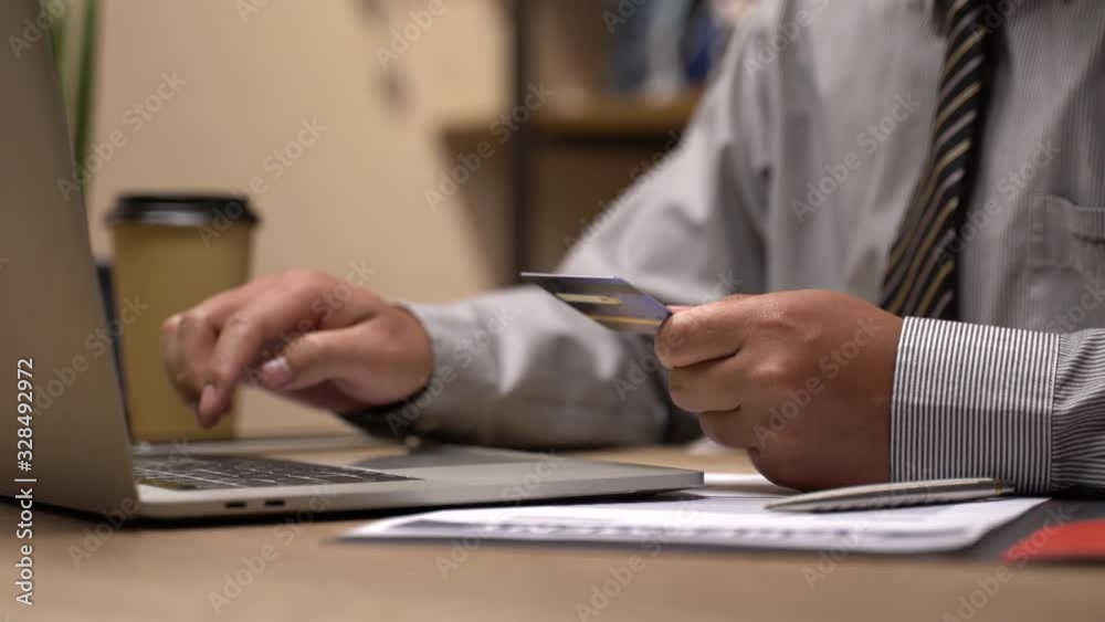Man paying bill, shopping online, inserting credit card number. A man paying for online shopping using laptop and credit card. close up Man paying bill, shopping online, inserting credit card number. A man paying for online shopping using laptop and credit card. close up