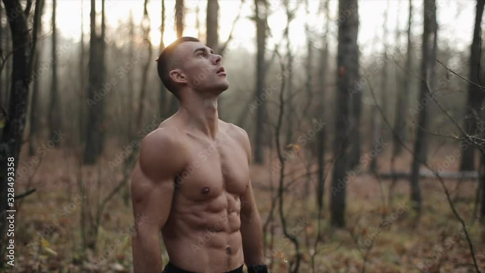 Male Athletic With Naked Torso Stands In The autumn forest Does Breathing Exercises. autumn leaves fall from trees. Slow motion. Male Athletic With Naked Torso Stands In The autumn forest Does Breathing Exercises. autumn leaves fall from trees. Slow motion.