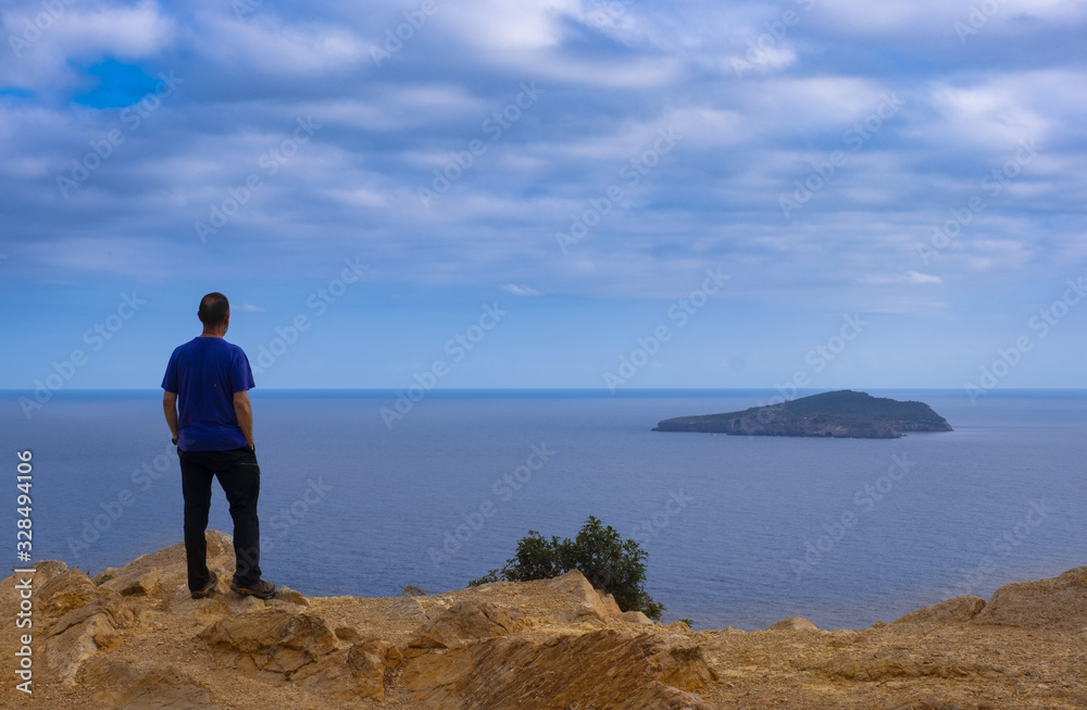Senior man watching the landscape of Tagomago Island from Punta Grossa in Cala de San Vicente, Ibiza