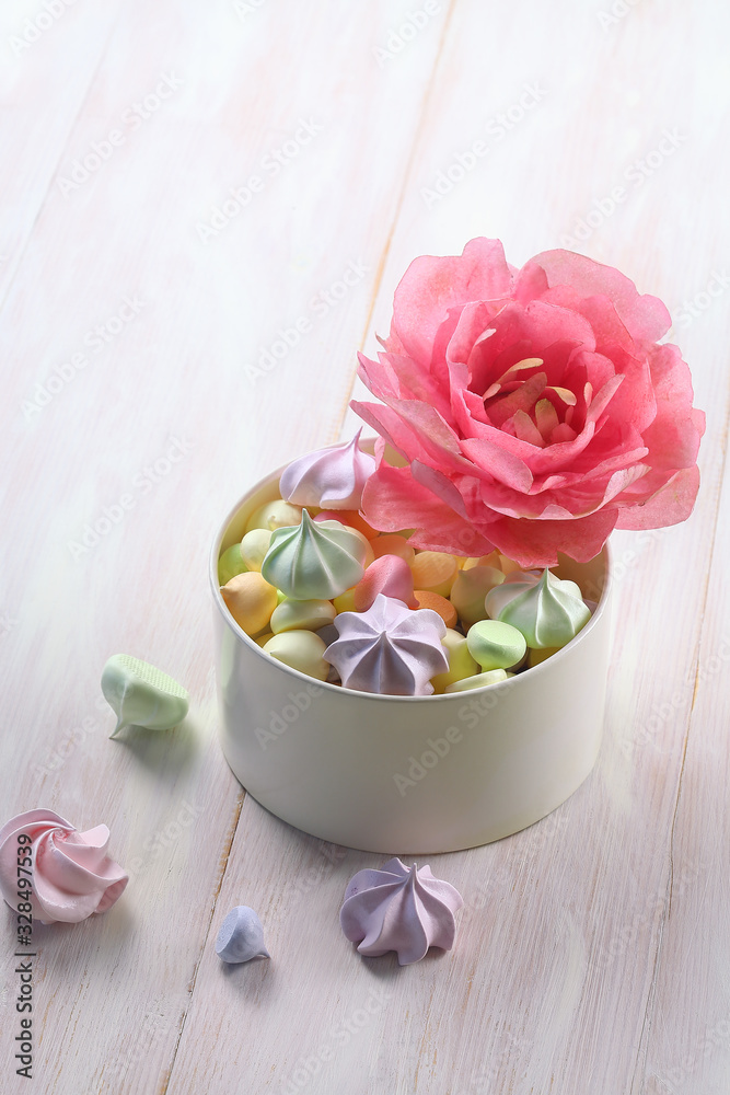 Wafer Paper Flower - Pink Peony - and colored meringue cookies, on white wooden background. Wafer Paper Flower - Pink Peony - and colored meringue cookies, on white wooden background.