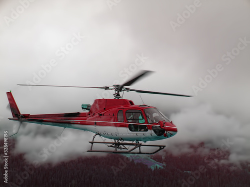 Red helicopter flying in fog