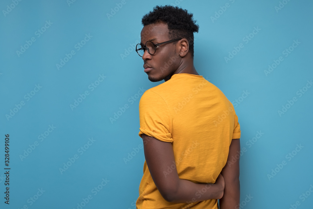 black man in glasses and yellow t-shirt turning back. black man in glasses and yellow t-shirt turning back.