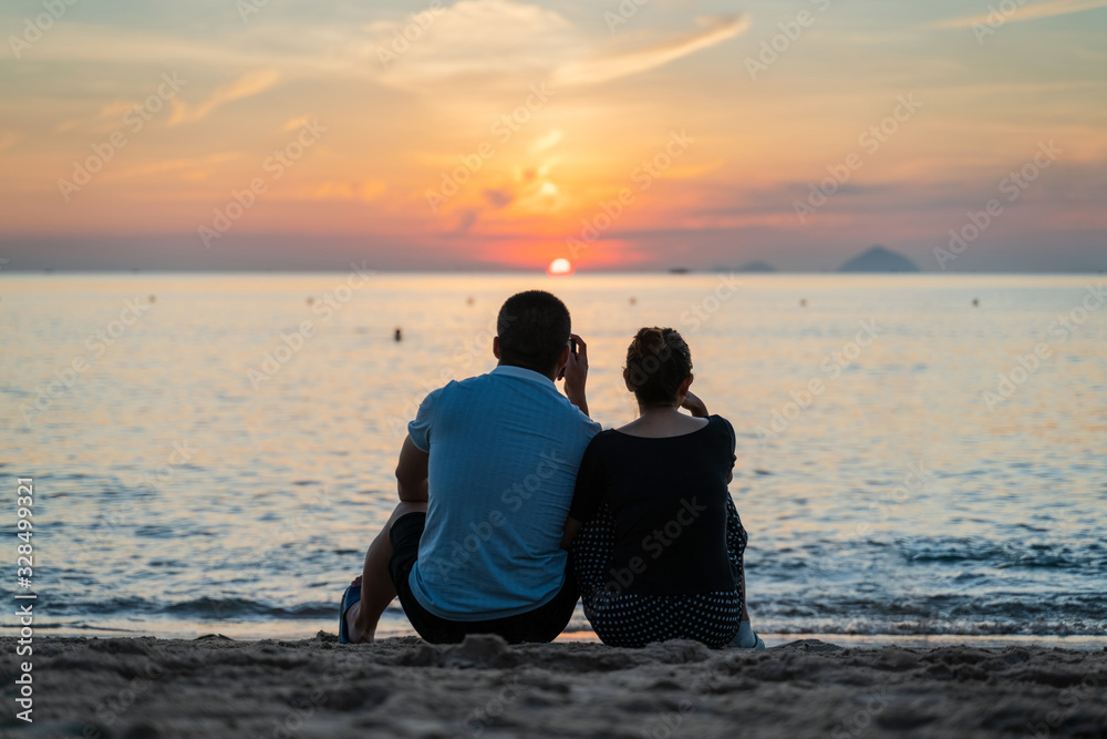 Couple sit in the sunset with silhouette scene Couple sit in the sunset with silhouette scene