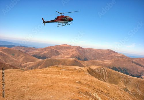 Red helicopter above the mountain