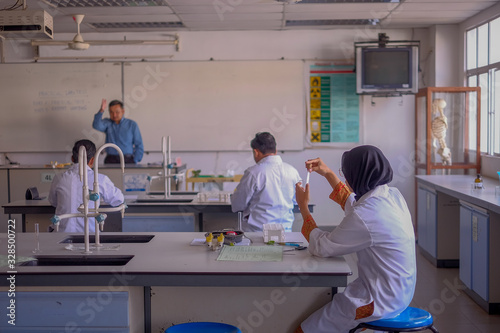 Malaysia - March 2, 2020: Students practice microsurgery in laboratory rat in University. Surgeon perform vascular anastomosis. Medical concept. Selective focus at surgeon 's hand.